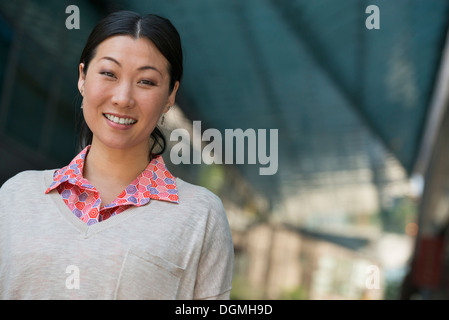 La gente di affari in movimento. Una donna in maglia rosa e maglione beige. Foto Stock