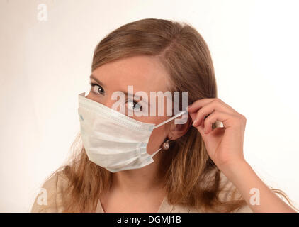 Giovane donna mette su una faccia in maschera, Skane, Ystad Foto Stock