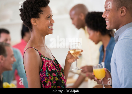 Networking festa o evento informale. Un uomo e una donna con una folla intorno a loro. Foto Stock