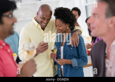 Networking festa o evento informale. Un uomo e una donna con una folla intorno a loro. Foto Stock