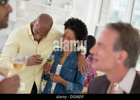 Networking festa o evento informale. Un uomo e una donna con una folla intorno a loro. Foto Stock