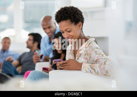 Evento di office. Una donna controllando il suo smart phone. Foto Stock