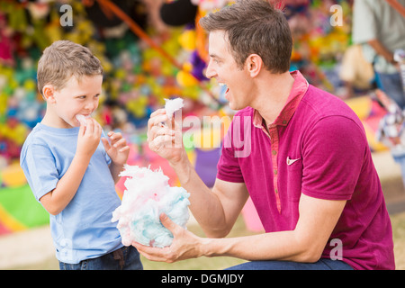 Stati Uniti d'America, Utah, Salt Lake City, Padre Felice con il figlio (4-5) nel parco dei divertimenti di mangiare la caramella di cotone Foto Stock