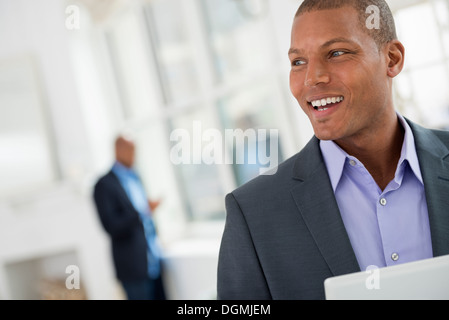 La gente di affari. Un giovane uomo in un vestito con una tavoletta digitale. Foto Stock