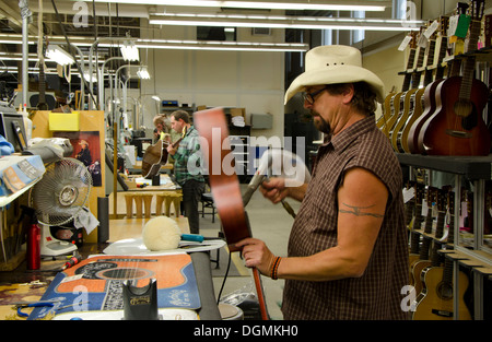 Uomo al lavoro su chitarra durante il processo di produzione a Martin Guitars factory a Nazareth, Pennsylvania, STATI UNITI D'AMERICA Foto Stock