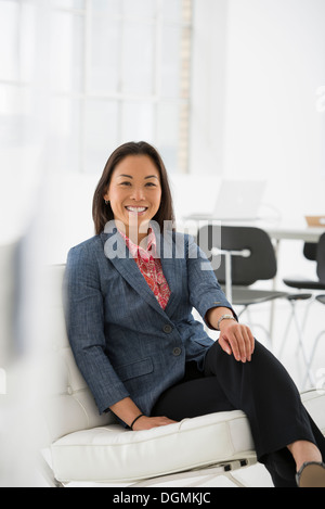 Business. Una donna seduta relax su una sedia confortevole. Foto Stock