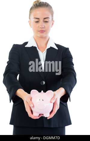 Grave chic imprenditrice presentando un salvadanaio Foto Stock