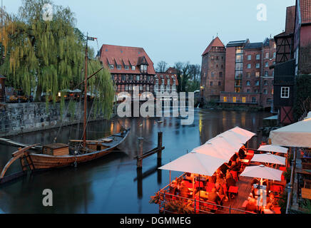 Sale storiche porta sul fiume Ilmenau, atmosfera serale, illuminato ristorante Le Terrazze, Lueneburg, Bassa Sassonia Foto Stock