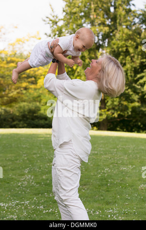 Paesi Bassi, South Holland, Oud-Beijerland, nonna mentre tiene il suo nipote (12-17 mesi) in aria Foto Stock