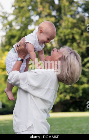 Paesi Bassi, South Holland, Oud-Beijerland, nonna mentre tiene il suo nipote (12-17 mesi) in aria Foto Stock