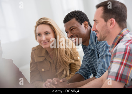 Ufficio. Un gruppo di quattro persone, due uomini e due donne seduti a parlare. Foto Stock