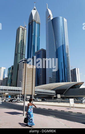 Singolo pedone davanti di grattacieli, Sheikh Zayed Road, Centro Finanziario Internazionale di Dubai, DIFC, Dubai Foto Stock