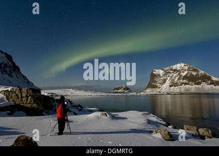 Fotografo a scattare foto di luci polari (Aurora boreale), nella baia di Vikbukta, Vestvagoya, Lofoten, Norvegia, Europa Foto Stock