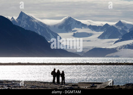 Sagome dei partecipanti alla spedizione di fronte alla montagna e panorama sul ghiacciaio di Smeerenburgbreen, Smeerenburgfjorden Foto Stock