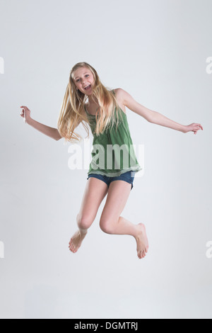 Studio shot della ragazza adolescente (14-15) jumping Foto Stock