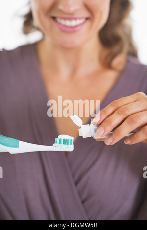 Donna che strizza dentifricio dal tubo allo spazzolino elettrico sopra il  lavandino in bagno, primo piano Foto stock - Alamy