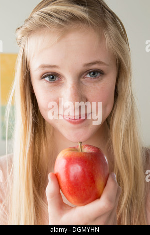 La ragazza (14-15) azienda apple Foto Stock