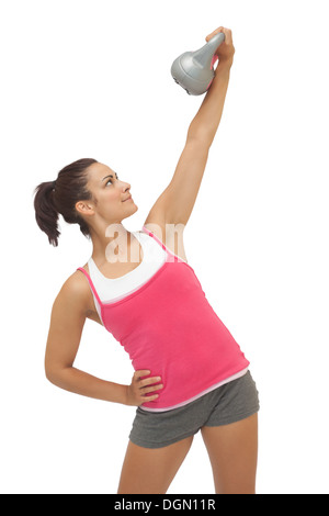 Felice sporty brunette holding grigio e kettlebell Foto Stock