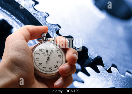 Mano azienda cronometro e tre ruote dentate in acciaio Foto Stock