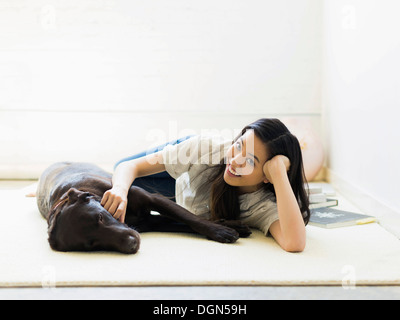 Ritratto di donna con cane sdraiato sul pavimento Foto Stock