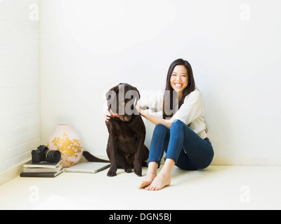 Ritratto di donna con cane seduto sul pavimento Foto Stock