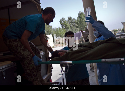 Provincia KHOWST, Afghanistan - I Medici con l esercito nazionale afgano caricare una simulazione di incidente nella parte posteriore di un campo per lettiera ambulanza, durante una massa-casualty esercizio su Camp Parsa, Afghanistan, Ottobre 12, 2013. Foto Stock