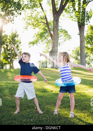 Stati Uniti d'America, Utah, Salt Lake City, due bambini (4-5, 6-7) giocando con anelli gonfiabile in posizione di parcheggio Foto Stock