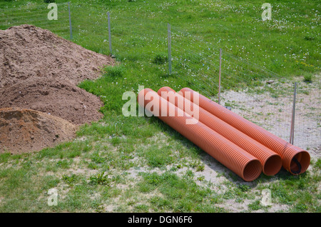 Area di costruzione con tubi di plastica su un prato Foto Stock