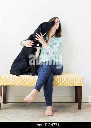 Cane leccare la donna sulla faccia Foto Stock