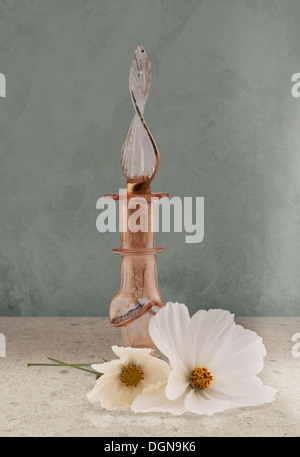 Una immagine composita di vetro di una bottiglia di profumo di fiori bianchi. Foto Stock