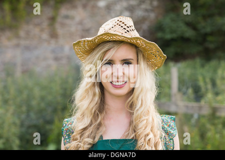 Carino giovane donna che indossa un cappello di paglia Foto Stock
