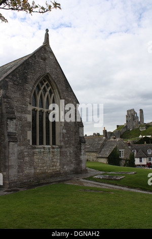 Parete ovest di Corfe Castle chiesa parrocchiale di Sant'Edoardo il martire, con il castello in background. Foto Stock