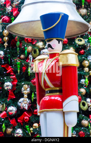 Close up su una tavola di legno schiaccianoci con uno sfondo di albero di Natale e ornamenti Foto Stock