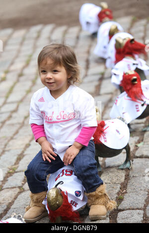 Boston, Massachusetts, USA. 23 Ott, 2013. Anysia Barlow, 2, di Boston controlla il famoso ''make modo per le ochette'' statua in Boston Public Garden di Boston, Massachusetts che è decorato in Boston Red Sox maglie e le barbe come Boston Red Sox prendere a Saint Louis Cardinals nella serie Mondiale. Credito: Nicolaus Czarnecki/METRO US/ZUMAPRESS.com/Alamy Live News Foto Stock