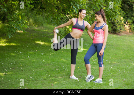 Montare due happy amici stretching prima di una corsa Foto Stock