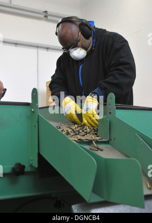 Darren Williams, un gestore di munizioni con proiettili Centro Europa e un nativo di Greenville, S.C., ispeziona vuoto cartucce in ottone in uno scomparto di ispezione tecnica per le cartucce sono ripartiti per un granulatore in ottone macchina all'esercito Miesau Depot Foto Stock