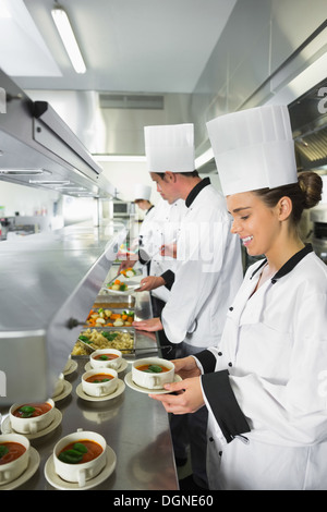Quattro chef operanti in una cucina di occupato Foto Stock