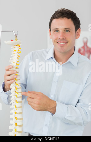 Bello allegro medico puntando al modello dello scheletro Foto Stock