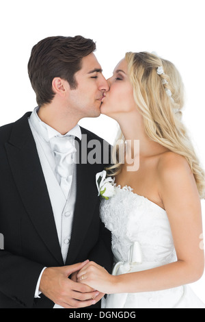 I giovani sposi in posa kissing ogni altro Foto Stock