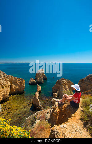 Tourist affacciato sulla scogliera di Ponta da Piedade, Algarve, Portogallo, Europa Foto Stock