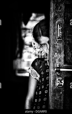 Rurale villaggio indiano ragazza in piedi in casa sua porta. Andhra Pradesh, India. Monocromatico Foto Stock