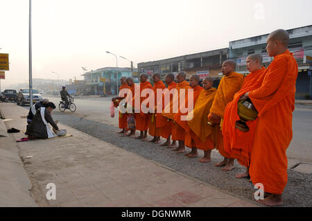 Mendicanti buddista nelle prime ore del mattino nella strada principale della città di Pahnsavan, Laos, Asia sud-orientale, Asia Foto Stock