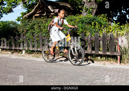 Ragazza di andare a scuola in bici, La Digue Island, Seychelles, Africa, Oceano Indiano Foto Stock