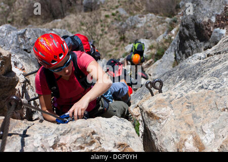 Gli arrampicatori salendo una via ferrata sul Monte Albano al di sopra di Mori, Trentino, Italia, Europa Foto Stock