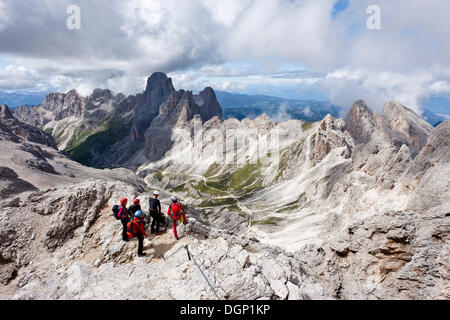 Gli alpinisti di arrampicata in montagna Kesselkogel tramite la via ferrata sopra il Grasleitenpass, gruppo Catinaccio sul retro Foto Stock