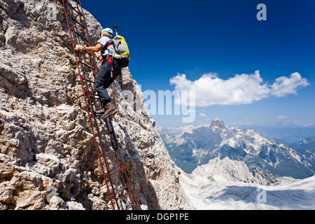 Alpinista salendo la Via Ferrata Ivano Dibona arrampicata fino alla vetta del Monte Cristallo al vertice del cristallino Foto Stock