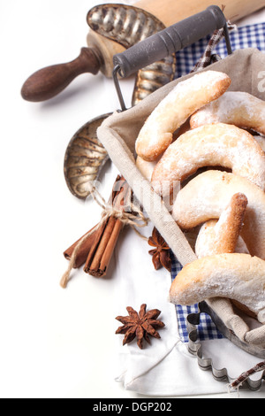 In casa i cookie di zucchero a mezzaluna in legno con il matterello e spezie su bianco Foto Stock