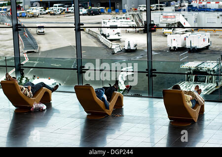 Sala partenze con tre passeggeri in attesa, aeroporto Charles de Gaulle di Parigi, Francia, Europa Foto Stock