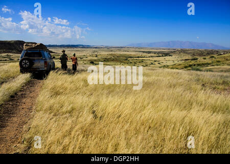 Padre e figlio esaminando la distrance, monte Brandberg, Damaraland, Namibia, Africa Foto Stock