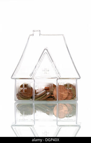 Casa trasparente con monete, immagine simbolica per la trasparenza nel mercato immobiliare, casa costi di costruzione Foto Stock
